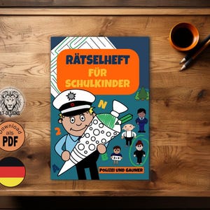 Könnte beinhalten: Ein Kinder-Aktivitätsbuch mit dem Titel "Rätselheft für Schulkinder" mit einem Cartoon-Polizisten, der eine große Zuckertüte hält. Das Buch liegt auf einer Holzoberfläche mit einer kleinen Tasse und Bleistiften.