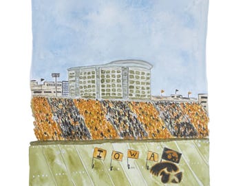 May include: Watercolor painting of a stadium scene with a blue sky background. The stands are filled with fans in black and gold. The field has the word "IOWA" and a Hawkeye logo. A large building is in the background.
