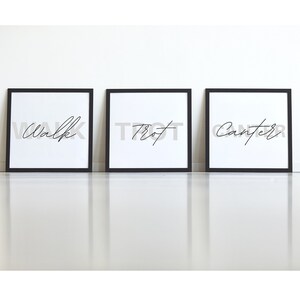 May include: Three black framed prints with white backgrounds and black calligraphy. The prints read "Walk", "Trot", and "Canter".