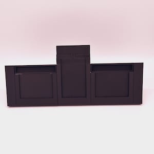 Puede incluir: Tres marcos rectangulares negros con un marco negro más pequeño en la parte superior. Los marcos están hechos de un material liso y mate.