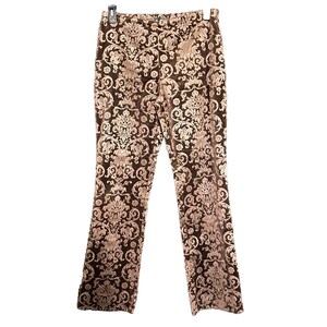 May include: Brown velvet pants with a light brown floral damask pattern. The pants are hanging from a hanger and have a straight leg cut. The fabric has a soft, luxurious appearance.