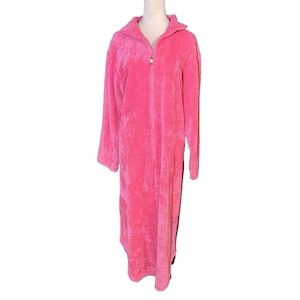 May include: A long, plush, pink robe with a zipper closure and a collar. The robe is made of a soft, fuzzy material and has long sleeves. The zipper has a gold-colored pull.