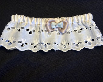 Könnte beinhalten: Weißes Spitzen-Strumpfband mit einer Schleife aus Satin in Hellblau und Beige.