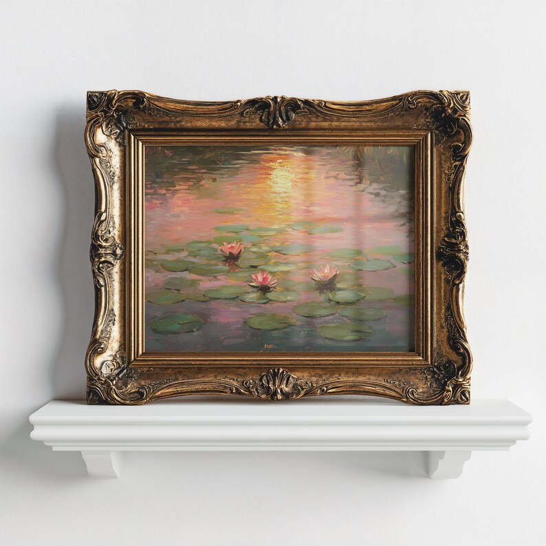 May include: A framed painting with a gold-coloured ornate frame, depicting water lilies. The artwork shows pink water lilies and lily pads on the water, with a sunset reflected. The frame has a detailed, vintage design, and the painting is on display.