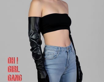 Könnte beinhalten: Schwarze Opernhandschuhe aus Kunstleder mit gerafftem Design. Die Handschuhe werden mit einem schwarzen Tube-Top und hellblauen Jeans kombiniert. Der Text "OH! GIRL GANG" ist in Pink dargestellt.