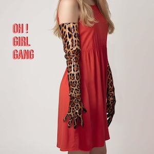 May include: A woman wearing a red dress and long leopard print gloves. The text "OH! GIRL GANG" is visible in the image.