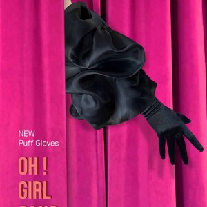 May include: A black puff sleeve with a black long glove peeking out from behind a bright pink curtain. The text "NEW Puff Gloves OH! GIRL GANG" is printed on the curtain.