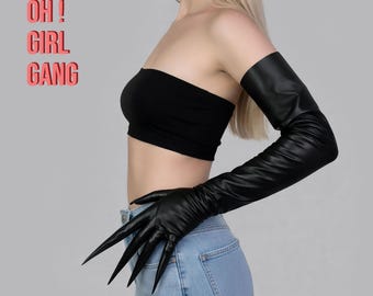 May include: Black faux leather gloves with long, sharp claws. The gloves extend up the arm. The image also includes a black tube top and the text "OH! GIRL GANG" in a pink box.