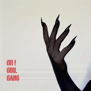 May include: A pair of sheer black opera-length gloves featuring long, pointed, claw-like fingertips. The text "OH ! GIRL GANG" is printed in a bold, red, sans-serif font on the left side of the frame against a plain, light-colored background.