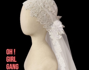 May include: A white lace bridal veil with floral and leaf patterns is displayed on a mannequin head. The veil is made of delicate lace and sheer fabric. The text "OH! GIRL GANG" is in the lower left corner.