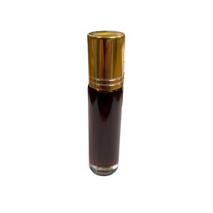 May include: A small, clear glass bottle with a gold cap filled with a dark brown liquid. The bottle has a roller ball applicator.