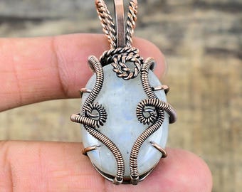 Peut inclure: Un pendentif en fil de cuivre enveloppé avec une pierre de lune blanche. Le pendentif a une bélière en fil torsadé.