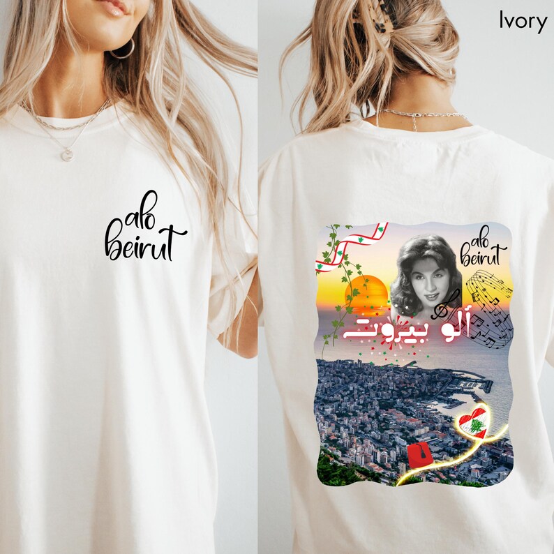 Puede incluir: Una camiseta color marfil con el texto "alo beirut" en letra cursiva negra en la parte delantera. La parte trasera muestra un gr&aacute;fico con el retrato de una mujer, notas musicales, un atardecer sobre una ciudad costera, la bandera libanesa y el texto.