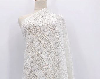 May include: White lace fabric with a geometric pattern. The fabric is displayed on a white mannequin.