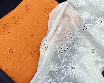 May include: Two pieces of fabric with an embroidered floral pattern. One piece is orange and the other is white.