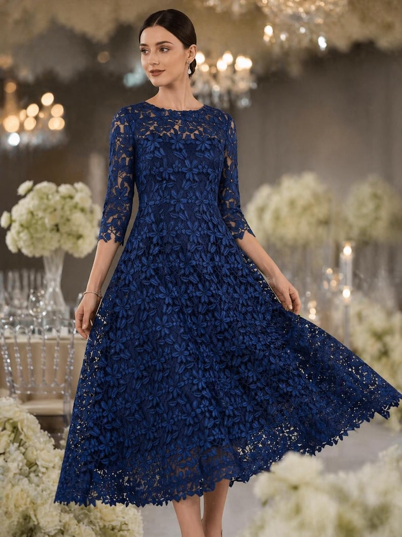 May include: A navy blue midi dress featuring three-quarter length sleeves and a round neckline. The garment is constructed from an intricate floral lace overlay that covers the bodice and the full, flared skirt, creating a textured appearance.