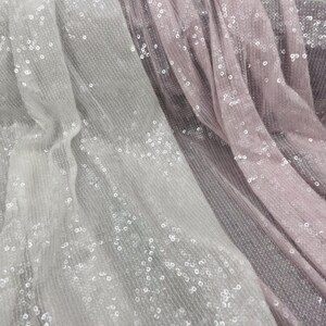 K&ouml;nnte beinhalten: Zwei St&uuml;cke durchsichtigen Stoffes mit Pailletten, ein wei&szlig;er und ein rosa, &uuml;bereinander gelegt.