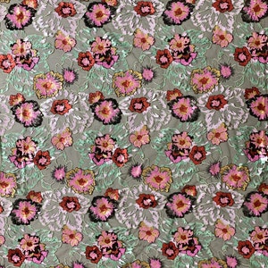 Puede incluir: Tela bordada con flores con lentejuelas en tonos de rosa, rojo, verde, dorado y negro sobre un fondo de malla transparente.