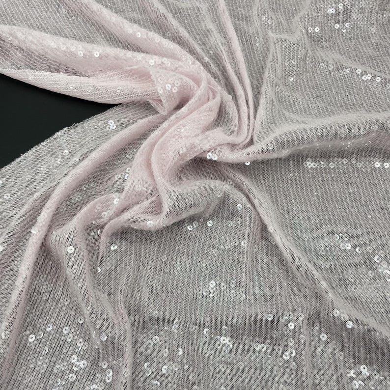 K&ouml;nnte beinhalten: Rosa paillettenbesetzter Stoff mit einer zarten, durchsichtigen Textur. Die Pailletten sind klein und gleichm&auml;&szlig;ig verteilt, wodurch ein schimmernder Effekt entsteht.