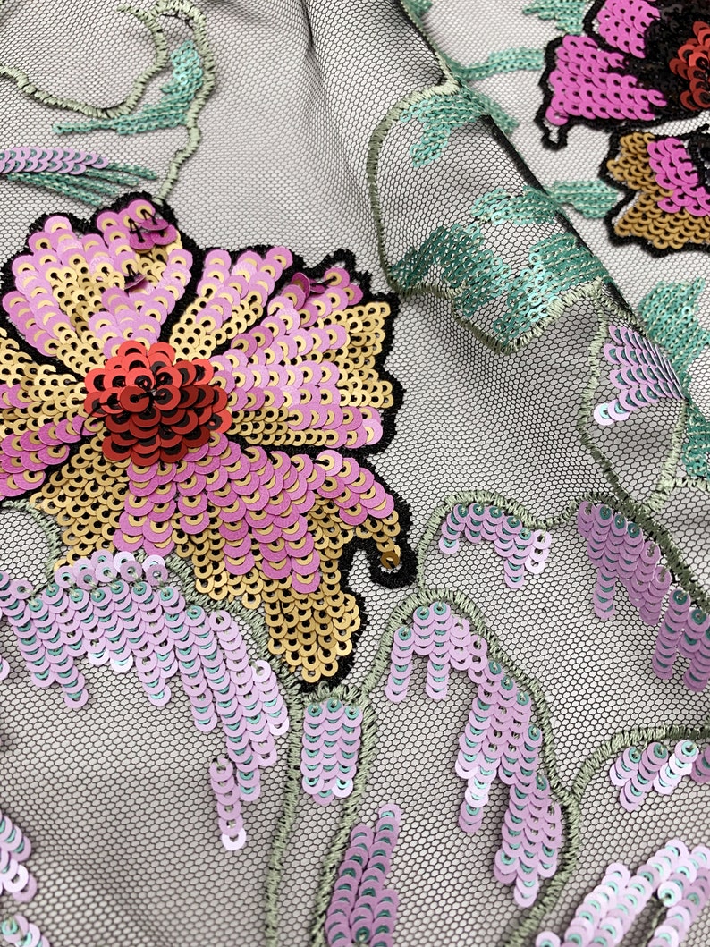 Puede incluir: Primer plano de una tela floral con lentejuelas en tonos rosa, dorado y verde. La tela tiene un fondo de malla.