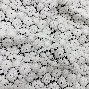 May include: White crochet fabric with a delicate floral pattern.