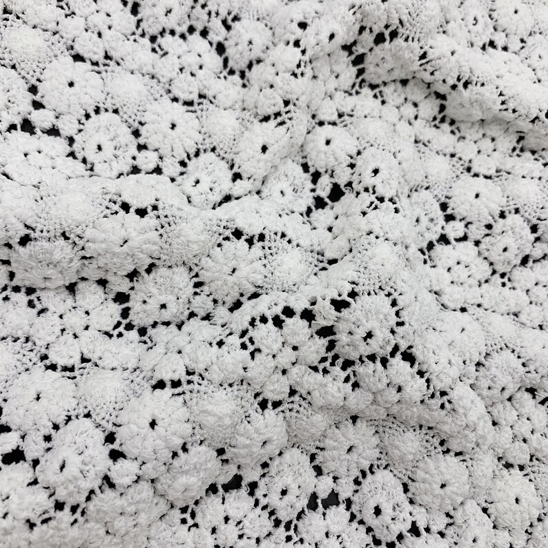 May include: White crochet fabric with a delicate floral pattern.
