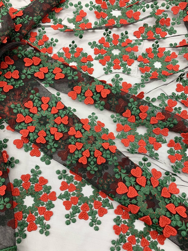 May include: Black mesh fabric with red and green embroidered hearts in a circular pattern.