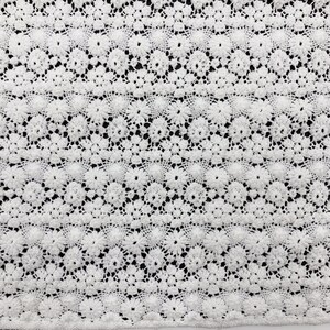 May include: White crochet fabric with a delicate floral pattern. The fabric has a textured, lace-like appearance.