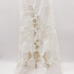 Peut inclure: Jupe en coton blanc avec un motif de dentelle florale d&eacute;licate. La dentelle est d&eacute;coup&eacute;e dans un motif floral, cr&eacute;ant un effet transparent.
