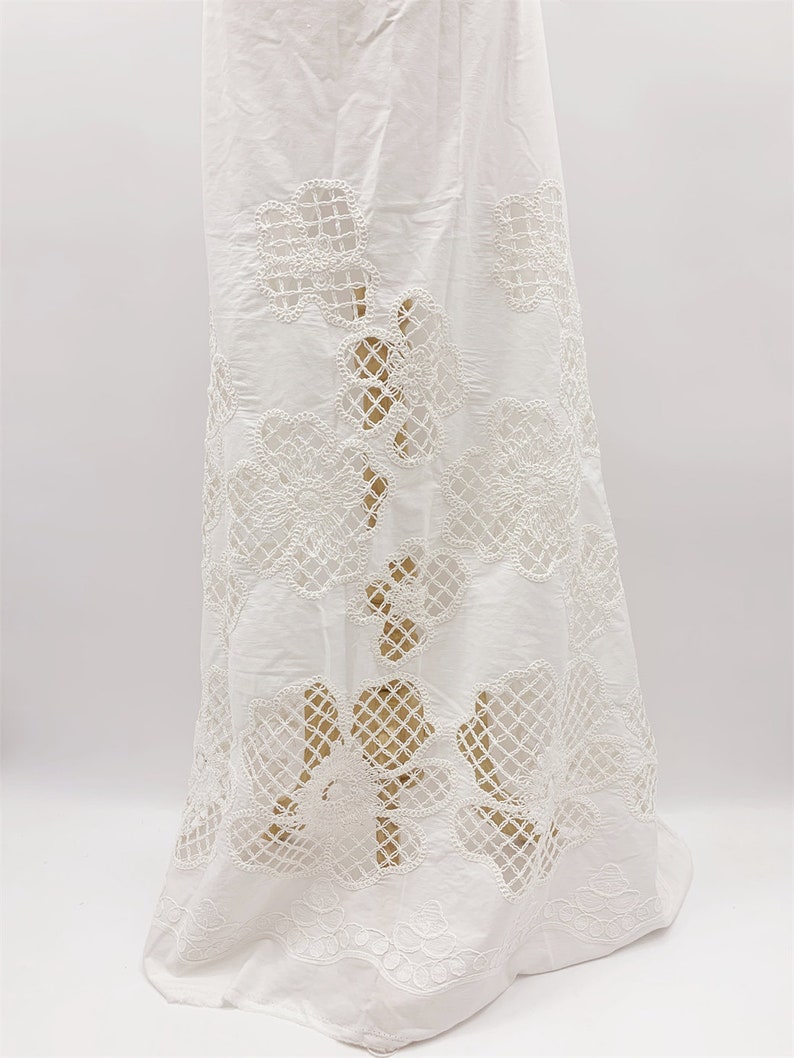 Peut inclure: Jupe en coton blanc avec un motif de dentelle florale d&eacute;licate. La dentelle est d&eacute;coup&eacute;e dans un motif floral, cr&eacute;ant un effet transparent.