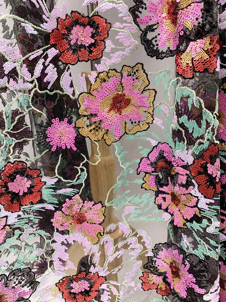 Puede incluir: Tela de malla negra con dise&ntilde;os florales bordados en lentejuelas rosas, rojas, doradas y verdes.