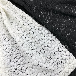 May include: White and black lace fabric with a delicate floral pattern. The fabric is soft and sheer, making it perfect for a variety of crafting projects.