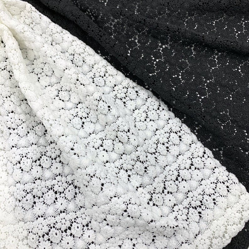 May include: White and black lace fabric with a delicate floral pattern. The fabric is soft and sheer, making it perfect for a variety of crafting projects.