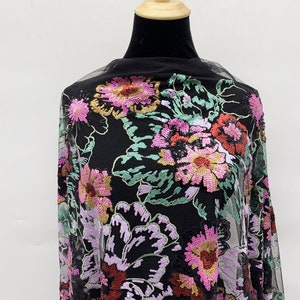 Puede incluir: Tela de malla negra con un patr&oacute;n floral bordado con lentejuelas en tonos de rosa, rojo, verde y dorado.