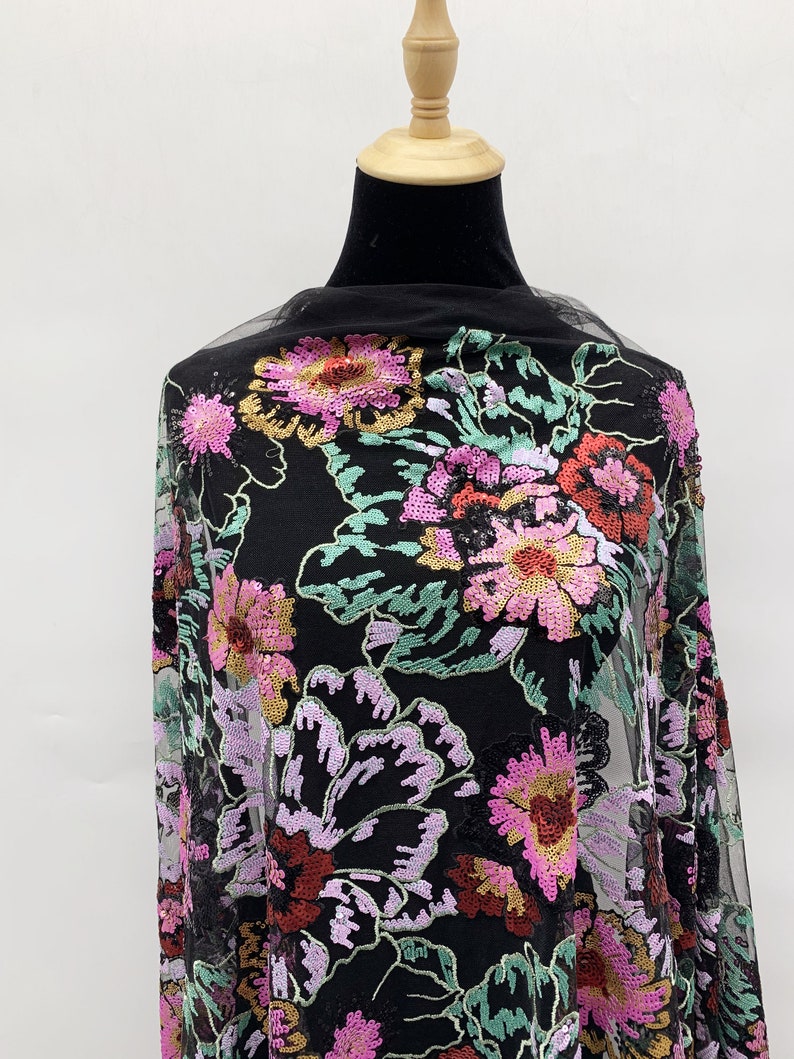 Puede incluir: Tela de malla negra con un patr&oacute;n floral bordado con lentejuelas en tonos de rosa, rojo, verde y dorado.