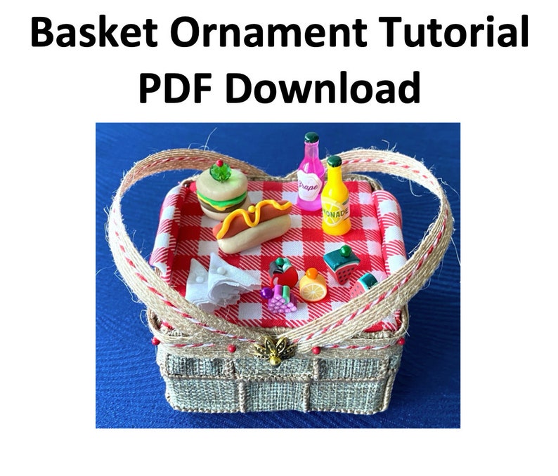 Pode incluir: Um ornamento de cesta de piquenique em miniatura com um pano xadrez vermelho e branco dentro. A cesta est&aacute; cheia de itens de comida e bebida em miniatura, incluindo um cachorro-quente, um hamb&uacute;rguer, fatias de melancia, um lim&atilde;o, uvas e duas garrafas de suco. A cesta &eacute; feita de material tecido e tem uma al&ccedil;a marrom.