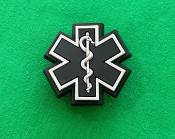 May include: Black and white star of life patch with a snake and staff symbol in the center.
