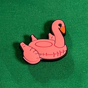 May include: Pink inflatable flamingo pool float with a black outline. The flamingo has a curved neck and a small beak.