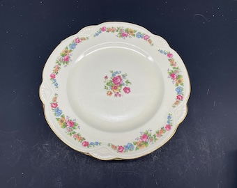 May include: A white ceramic soup bowl with a gold rim and a floral pattern in shades of pink, yellow, and blue.