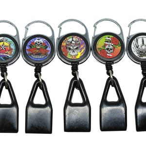 May include: Five retractable keychains with different skull designs. Each keychain has a black plastic lighter holder attached.