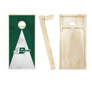 May include: A set of two wooden cornhole boards with a green and white design featuring the San Francisco 49ers logo. The boards are made of wood and have a hole in the center. The boards are set up for a game of cornhole.