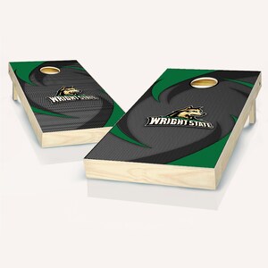 May include: A pair of wooden cornhole boards with a green and black design featuring the Wright State University logo and mascot. The boards are set up for a game of cornhole.