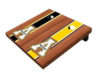 May include: A wooden cornhole set with a brown wood base and black and yellow stripes. The set features the Appalachian State University logo with the letter "A" and the word "Mountaineers".
