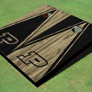 May include: A wooden cornhole game with a black and brown wood grain design. The boards feature a black and white geometric pattern with a white "F" logo on each board.
