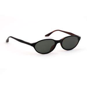 May include: Black oval sunglasses with dark lenses. The frames are black with brown arms. The sunglasses are set against a white background.