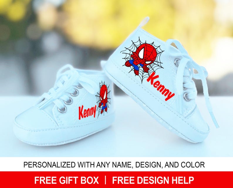 May include: White canvas high-top baby shoes with a red and blue Spiderman design and the name "Kenny" embroidered on the side.