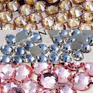 May include: Close-up of three groups of faceted rhinestones in different colors. The top group is a golden-brown color, the middle group is silver, and the bottom group is a light pink color. The text "PinkBlueSteps" is visible.