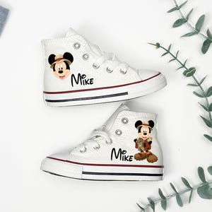 May include: White high-top sneakers with red and navy blue trim. Each shoe features a Mickey Mouse graphic and the name "Mike" in black script. The sneakers have white laces and a classic canvas design.