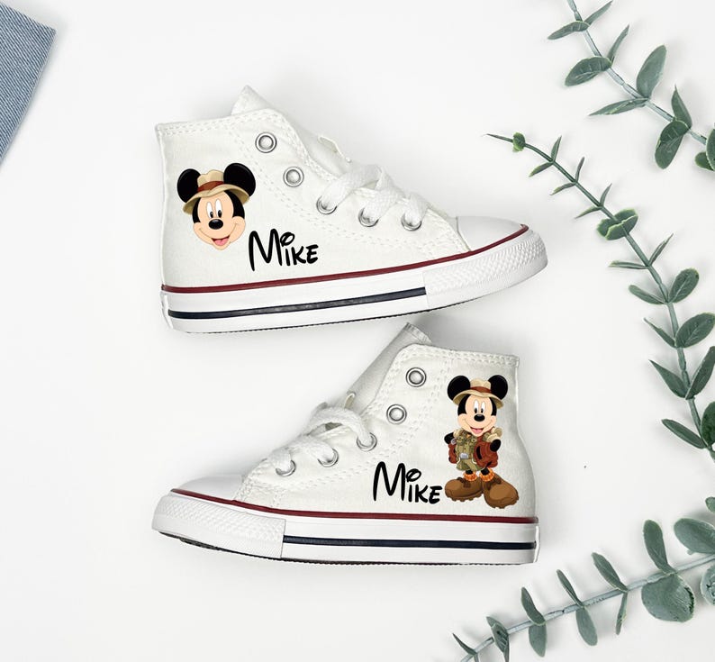 May include: White high-top sneakers with red and navy blue trim. Each shoe features a Mickey Mouse graphic and the name "Mike" in black script. The sneakers have white laces and a classic canvas design.