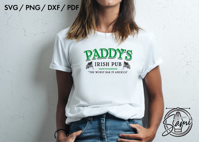 May include: A white t-shirt with a green and black graphic design that reads "Paddy's Irish Pub South Philadelphia "The Worst Bar in America".